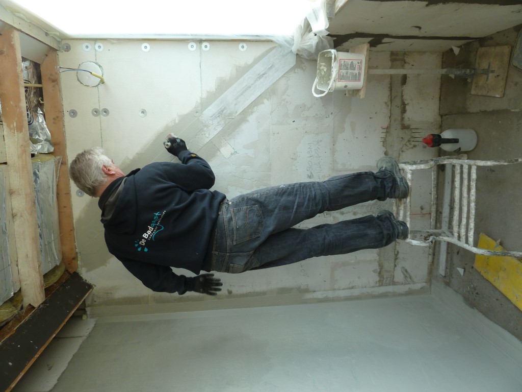 Gerard Bartels aan het werk in een badkamer in aanbouw