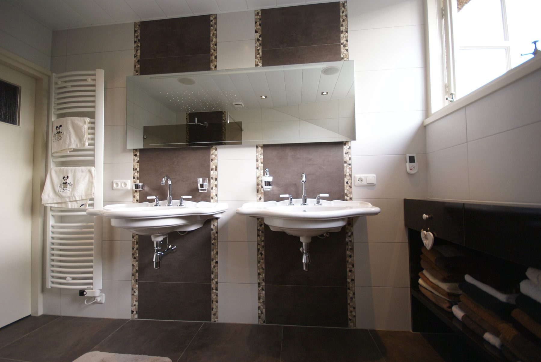 Badkamer met dubbele wastafel en mozaïekbanen, gerenoveerd door De Badgast